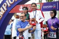 Melalui cabang olahraga atletik pada ajang Pekan Olahraga Nasional (Pornas) XVII Korps Pegawai Republik Indonesia (Korpri) Tahun 2025, atlet lari Kementerian Pemuda dan Olahraga (Kemenpora), Rumini, berhasil meraih medali emas pada nomor lari 5 kilometer (5K). (foto:raiky/kemenpora.go.id)