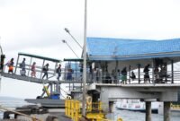 Penumpang berjalan menuju kapal feri melalui garbarata di Pelabuhan penyeberangan Merak–Bakauheni