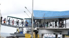 Penumpang berjalan menuju kapal feri melalui garbarata di Pelabuhan penyeberangan Merak–Bakauheni