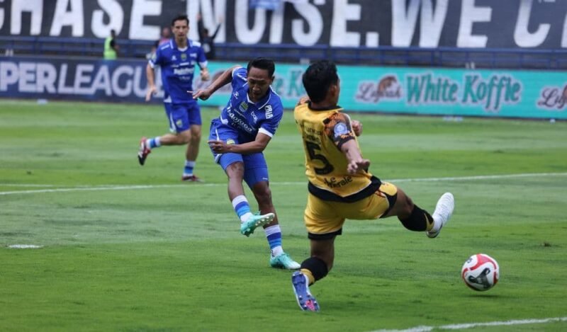 Foto: Beckham Putra saat melakukan tendangan jarak jauh dan coba di halangi oleh Rizky Ridho (Persib.co.id)