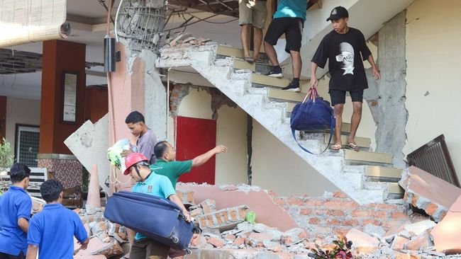 Warga dievakuasi dari bangunan Hotel Jayakarta yang runtuh akibat gempa bermagnitudo 7,7 di Labuan Bajo, Nusa Tenggara Timur, Indonesia, Sabtu (15/8/2026). (REUTERS/Stringer)